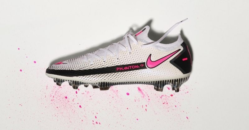 nike phantom gt elite football boots in white and pink on grey background