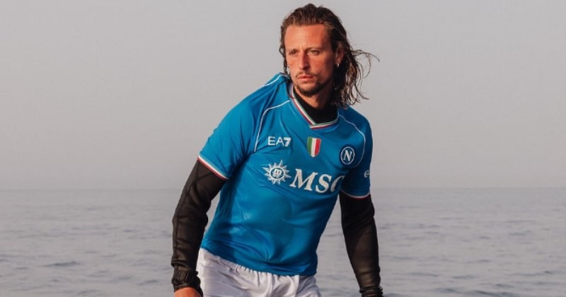 man surfing wearing napoli 2023-24 home shirt in blue