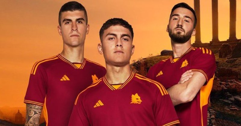 three players wearing as roma 2023-24 home shirt in red and orange