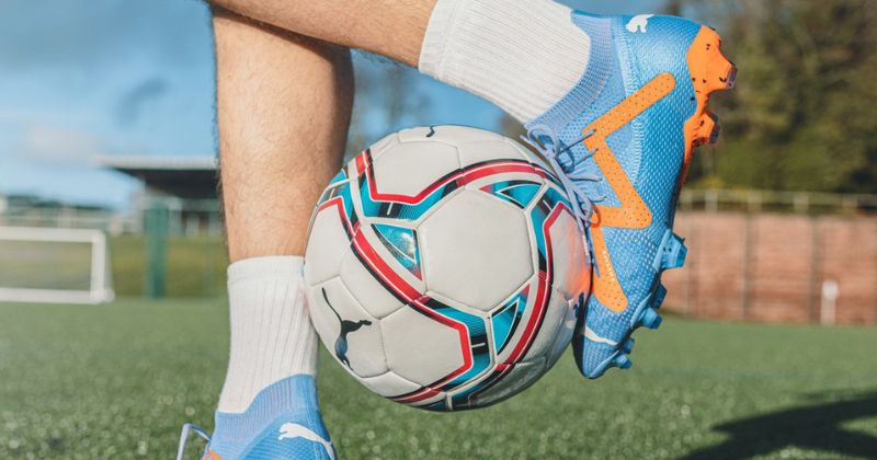 puma future football boots in blue and orange on feet