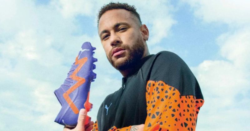 neymar holding puma future football boots in blue and orange