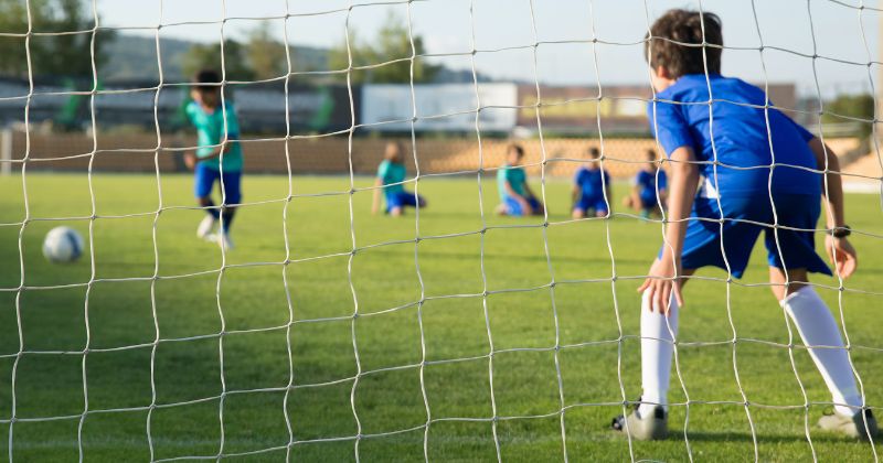 two children football training together with goals