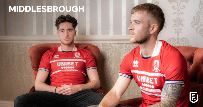 two players sat on sofas wearing middlesbrough 2023-24 home shirts in red and white